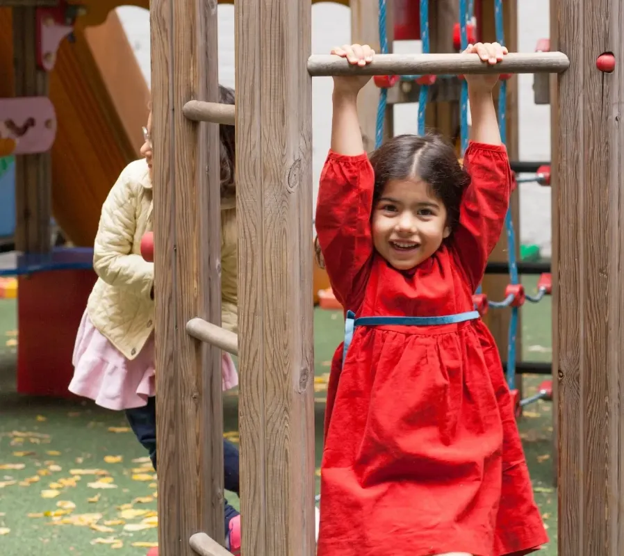 child swinging on monkey bars