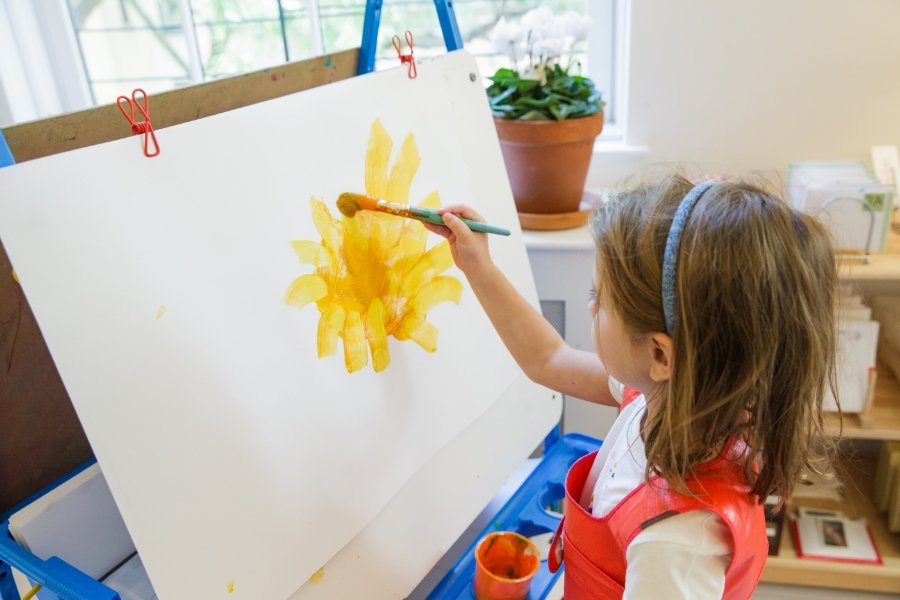 student painting a flower