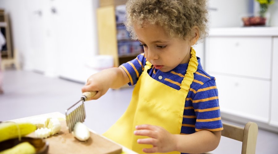 Toddler student practicing cutting food